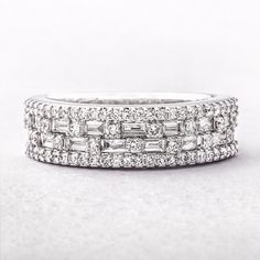 a white gold ring with baguetts of diamonds on it's sidestones