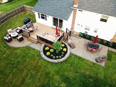 an aerial view of a backyard with patio furniture and fire pit in the foreground