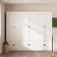 an empty room with white cupboards and drawers on the floor next to a window