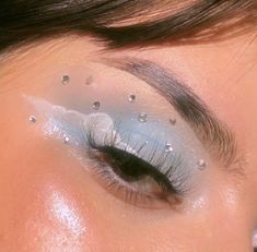 a woman's eye with blue and silver makeup