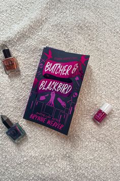 Flat lay of 'Butcher & Blackbird' by Brynne Weaver, a romance and thriller novel, displayed on a light textured surface with three metallic nail polishes in various shades: bronze, emerald, and fuchsia. Book Reviews