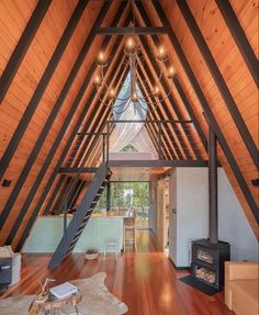 the inside of a house with wood floors and beams on the ceiling is lit by lights