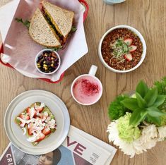 a wooden table topped with plates and bowls of food