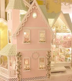 a pink doll house with lots of windows and decorations on the top floor in front of it