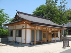 a small white building with wood trim around it