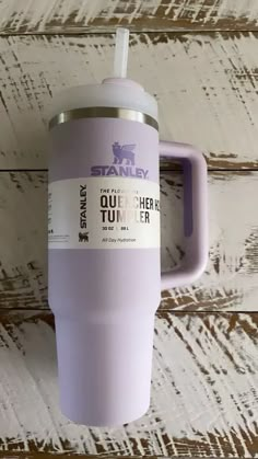 a purple tumbler cup with a straw sticking out of it's side on a wooden surface