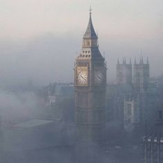 the big ben clock tower towering over the city of london on a foggy day