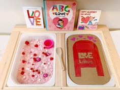 two trays filled with different types of crafts and books on top of a table