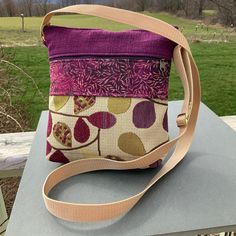 a small purse sitting on top of a table next to a green grass covered field