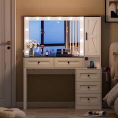 a dressing table with lights on it in a room next to a bed and door