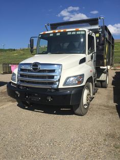 a dump truck parked on the side of a dirt road