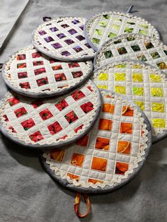 four quilted plates sitting on top of a table