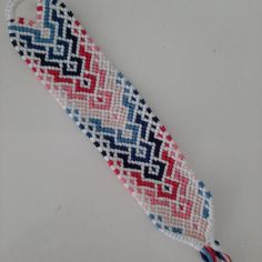 a piece of beaded material with red, white and blue designs on it's side