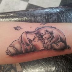 a tattoo on the arm of a person with a dog and cat hugging each other