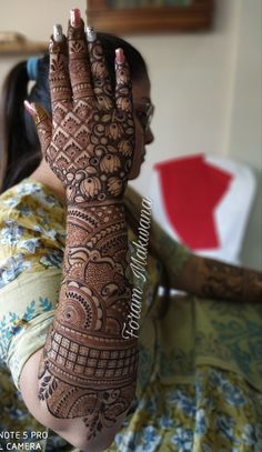 a woman with henna on her arm and hand