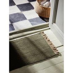 a basket is sitting on the floor next to a door with a checkered rug