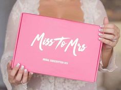 a woman holding up a pink box with the words miss to mrs written on it