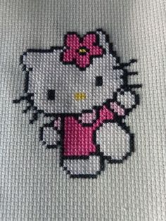 a hello kitty cross stitched onto a white shirt with pink bows on it's head