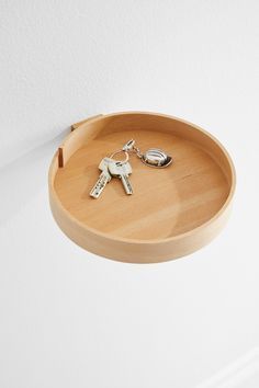 a wooden tray with two keys hanging from it's side and a keychain attached to the wall