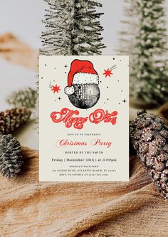 a christmas party card with pine cones and fir trees in the background, on top of a piece of wood