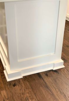 an empty white kitchen island with wood floors