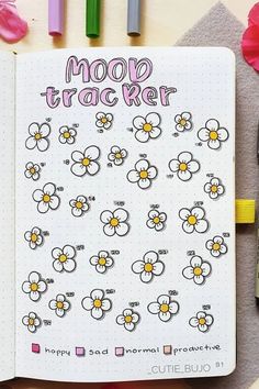 an open notebook with stickers on it and flowers in the pages next to them