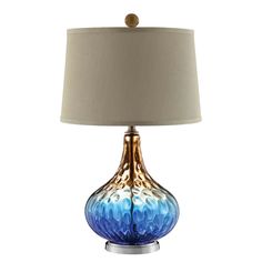 a blue and gold lamp with a beige shade on the top is sitting in front of a white background