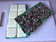 there is a green tray that has some chocolates on it and white squares in the middle