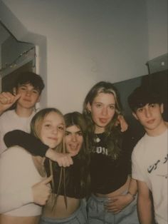 a group of young people standing next to each other in front of a bathroom mirror