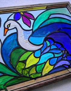 a stained glass peacock sitting on top of a table