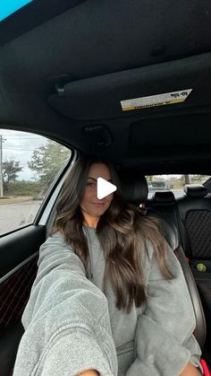 a woman sitting in the back seat of a car