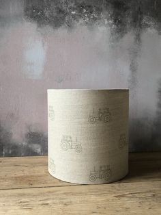 a round lamp shade with tractors printed on the fabric, sitting on a wooden surface