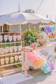 an ice cream stand is decorated with balloons and confetti for a baby shower