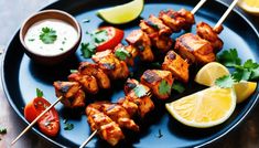 chicken skewers on a blue plate with lemon wedges and garnish