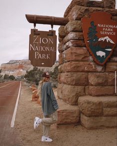 a man standing in front of a sign for the national park