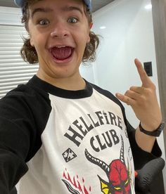 a young boy wearing a baseball cap making a funny face