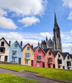 a row of multicolored houses with a church in the background