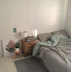 a bed sitting next to a nightstand with a lamp on top of it