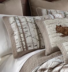 a bed topped with lots of pillows next to a wooden headboard and night stand