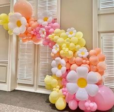 the balloon arch is decorated with flowers and balloons in pastel colors for a party