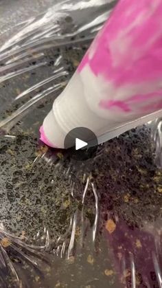 a close up of a pink and white toothbrush on top of some plastic wrap