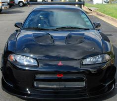 the front end of a black sports car parked in a parking lot