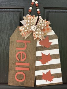 a door hanger decorated with fall leaves and the word hello written on it's side