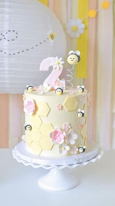 a cake decorated with bees and flowers on a table