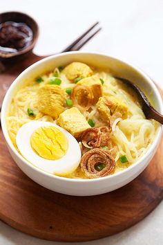 a bowl of ramen with an egg on top and chopsticks next to it