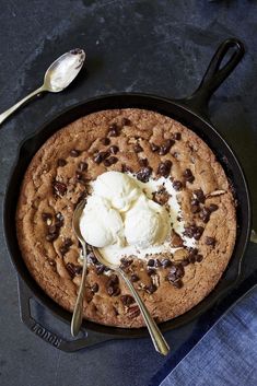 chocolate chip cookie with ice cream in a cast iron skillet on a dark surface