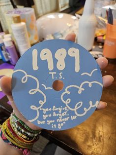 a person holding up a blue doughnut with writing on it