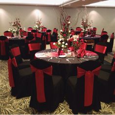 a banquet room set up with black and red chairs