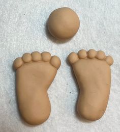 two clay feet and an egg on a white surface