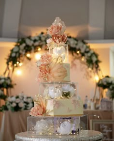 a three tiered wedding cake with flowers on top